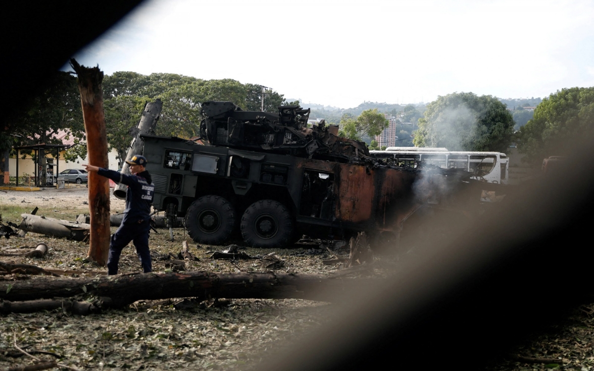 Lính cứu hỏa bên tổ hợp phòng không bị hỏa lực Mỹ phá hủy tại căn cứ quân sự La Carlota ở Caracas. Ảnh: Reuters.