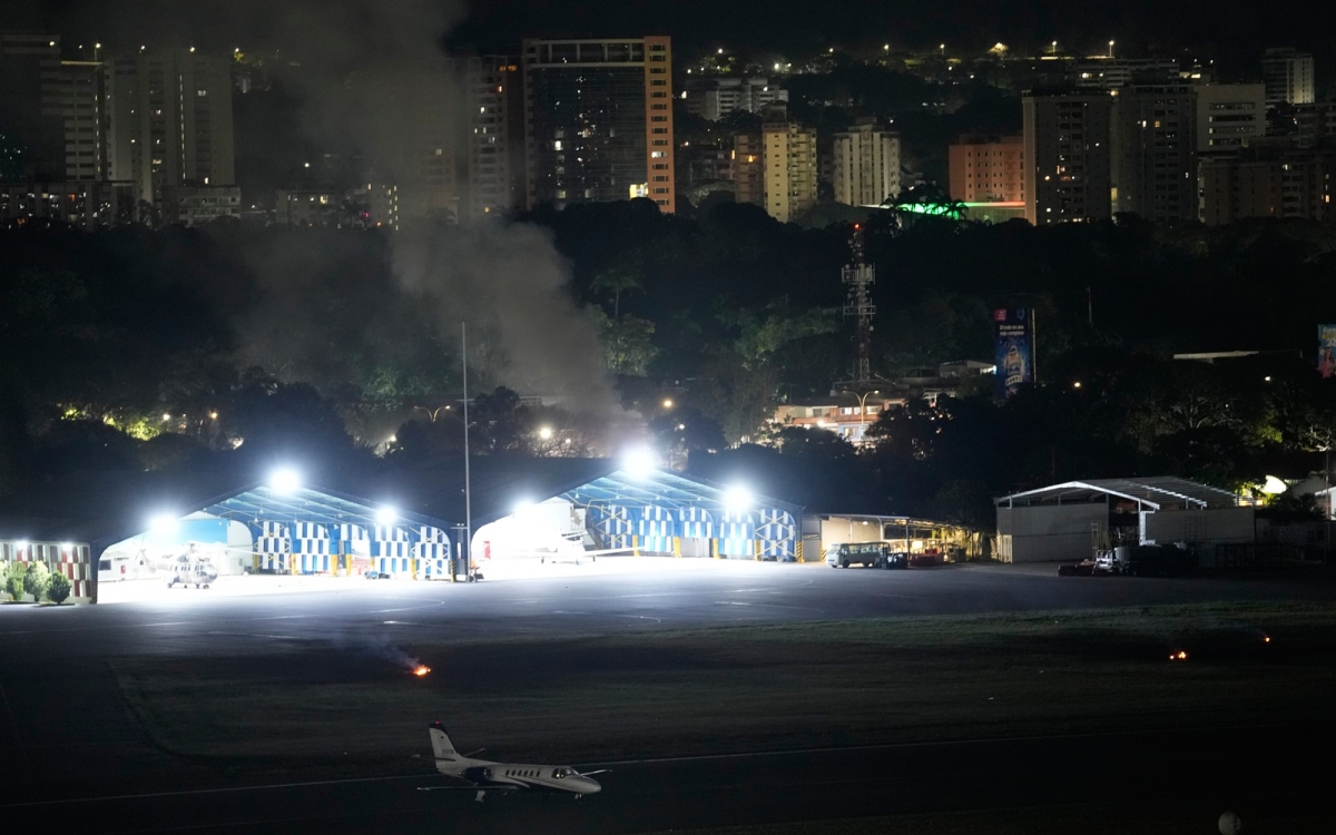 Khói tại sân bay La Carlota sau loạt vụ nổ ở thủ đô Caracas. Người ta khi đó nghe thấy được cả tiếng máy bay bay thấp. Ảnh: AP.