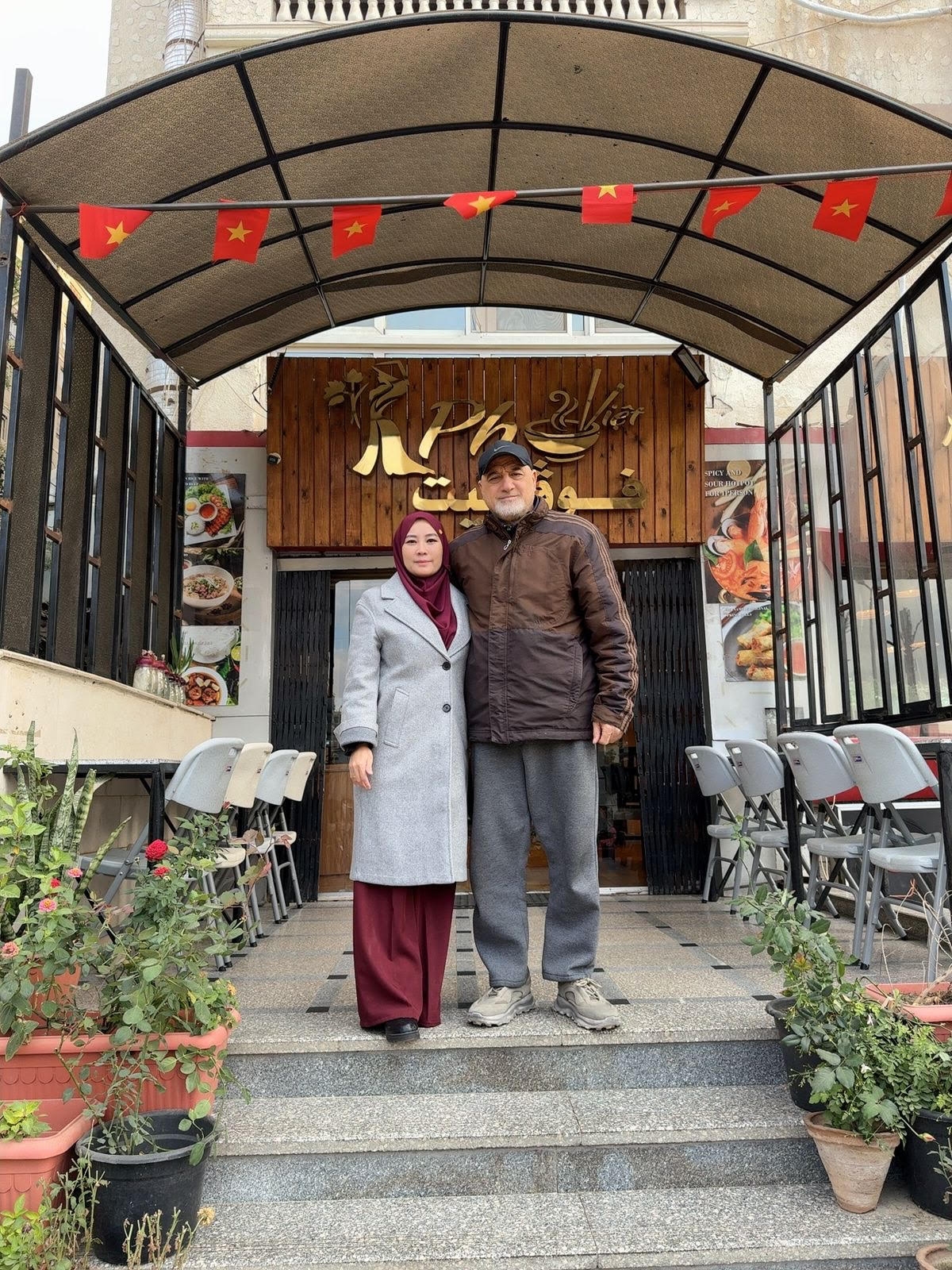 Chị Nguyễn Thị Vàng Ý và chồng (người Ai Cập) chụp ảnh trước quán Phở Việt do anh chị điều hành tại Cairo