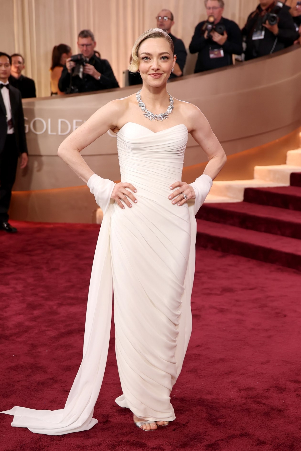 Amanda Seyfried lựa chọn phong cách cổ điển với đầm xếp nếp bất đối xứng của Versace. Chân váy dài chấm đất mang lại vẻ thướt tha, thanh lịch khi di chuyển. Trang phục toát lên thần thái quyền lực, sang trọng của Amanda Seyfried nhưng vẫn rất nữ tính.