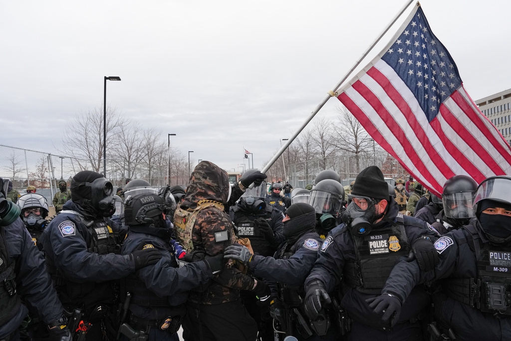 Một người biểu tình vẫy cờ Mỹ bị các nhân viên nhập cư liên bang bắt giữ bên ngoài Tòa nhà Liên bang Bishop Henry Whipple, hôm 15/1/2026, tại Minneapolis, Minnesota. Ảnh: AP