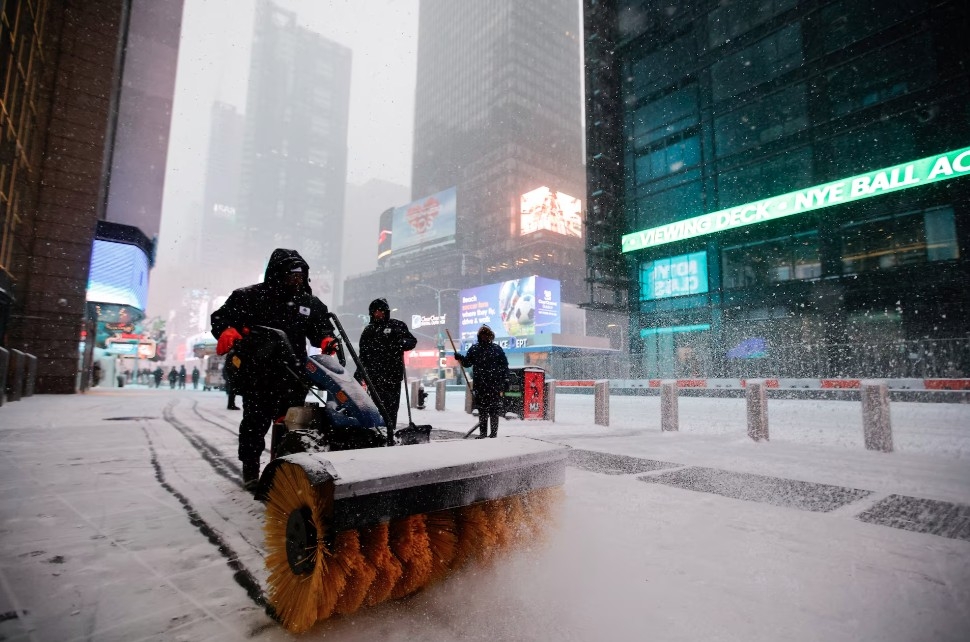 Công nhân dọn tuyết trên vỉa hè quanh khu vực Quảng trường Thời đại, New York ngày 25/1.