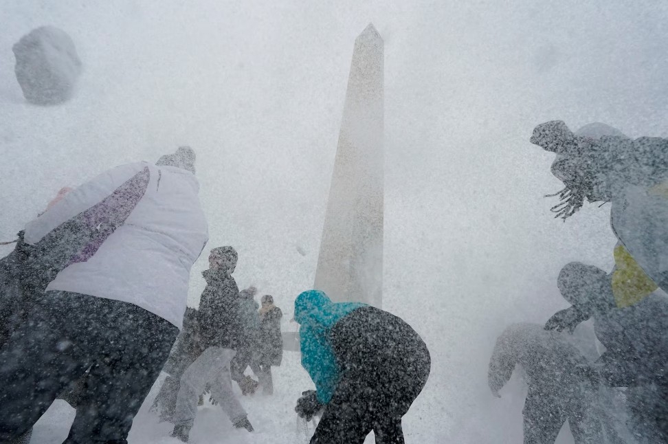 Người dân chơi ném bóng tuyết gần Đài tưởng niệm Washington trong lúc tuyết rơi tại Washington DC ngày 25/1.