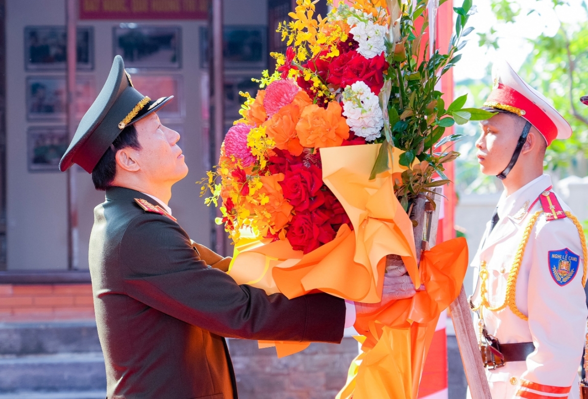 Đại tướng Lương Tam Quang chỉnh vòng hoa, dâng hoa tưởng niệm cố Bộ trưởng Trần Quốc Hoàn. (Ảnh: Phạm Bằng).