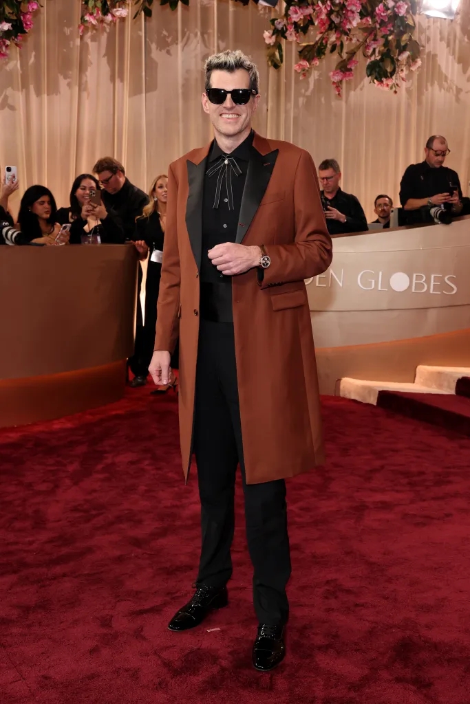 Timothy Simons lựa chọn áo vest dáng dài màu nâu của Brooks Brothers, tạo cảm giác thời thượng và nổi bật giữa không gian thảm đỏ.