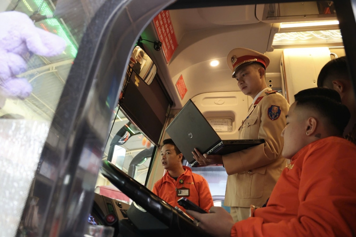 CSGT trích xuất dữ liệu camera giám sát hành trình trong cabin ô tô vận tải hành khách để kiểm tra. (Ảnh: Kinh tế đô thị)