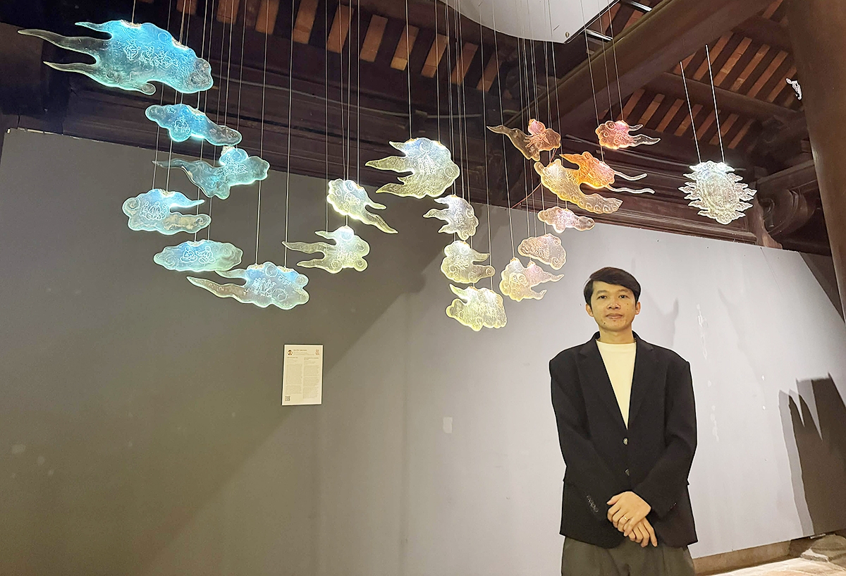 Hoạ sỹ Nguyễn Tuấn Dũng bên cạnh tác phẩm nghệ thuật của mình