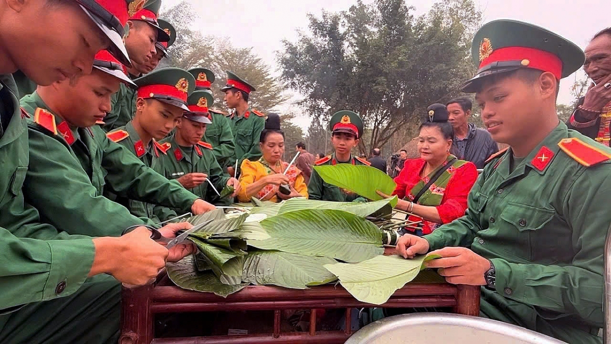 Cộng đồng các dân tộc đang hoạt động tại Làng cùng các chiến sĩ tham gia gói bánh chưng trong Chương trình "Bánh chưng xanh - Tết vì người nghèo" năm 2025. (Ảnh: Làng VHDLCDTVN)