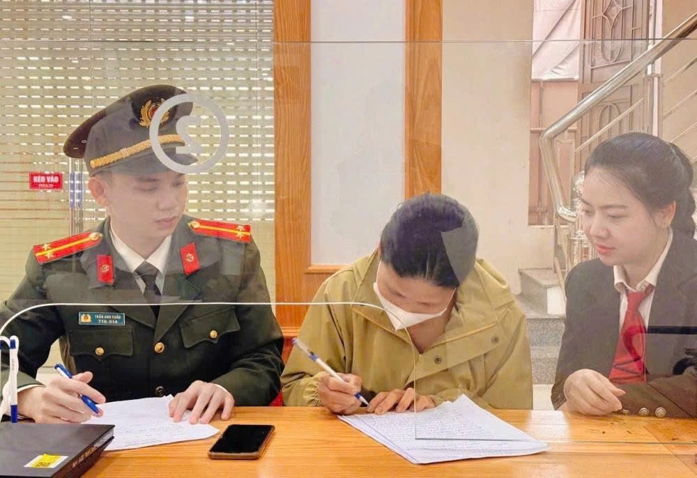 Lực lượng làm nhiệm vụ và nhân viên ngân hàng trấn an tinh thần và hướng dẫn người phụ nữ. (Ảnh: Công an cung cấp).