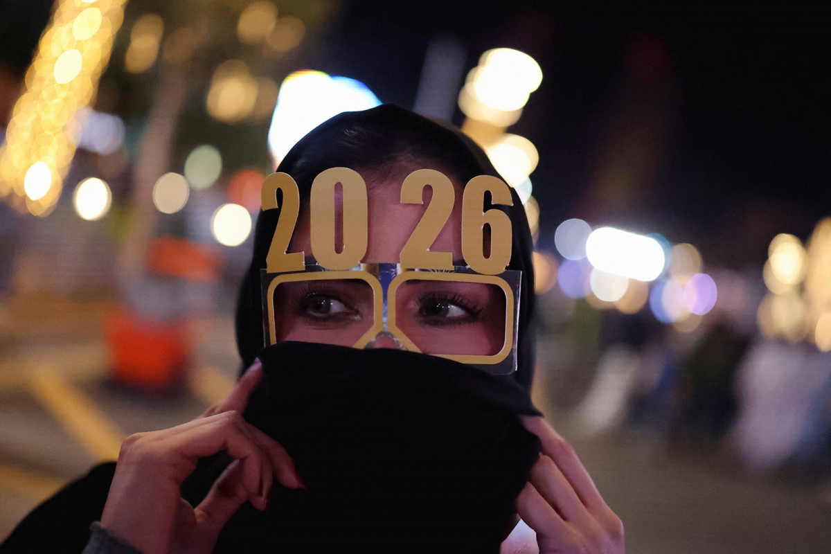 Người phụ nữ đeo kính có chữ "2026" trong lễ đón năm mới ở Lusail, Qatar, ngày 1/1/2026. Ảnh: Reuters.