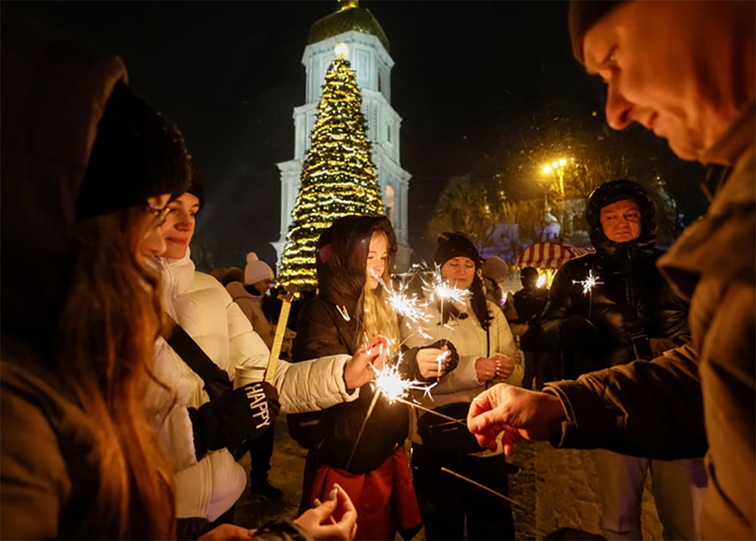 Mọi người cùng nhau chia sẻ khoảnh khắc đón năm mới ở thủ đô Kiev của Ukraine. Ảnh: Reuters.