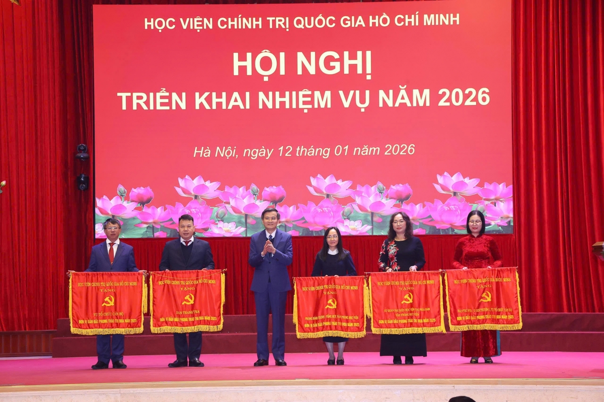 PGS.TS Đoàn Minh Huấn tặng danh hiệu Cờ thi đua của Học viện cho các tập thể (Ảnh: Văn Điệp/TTXVN)