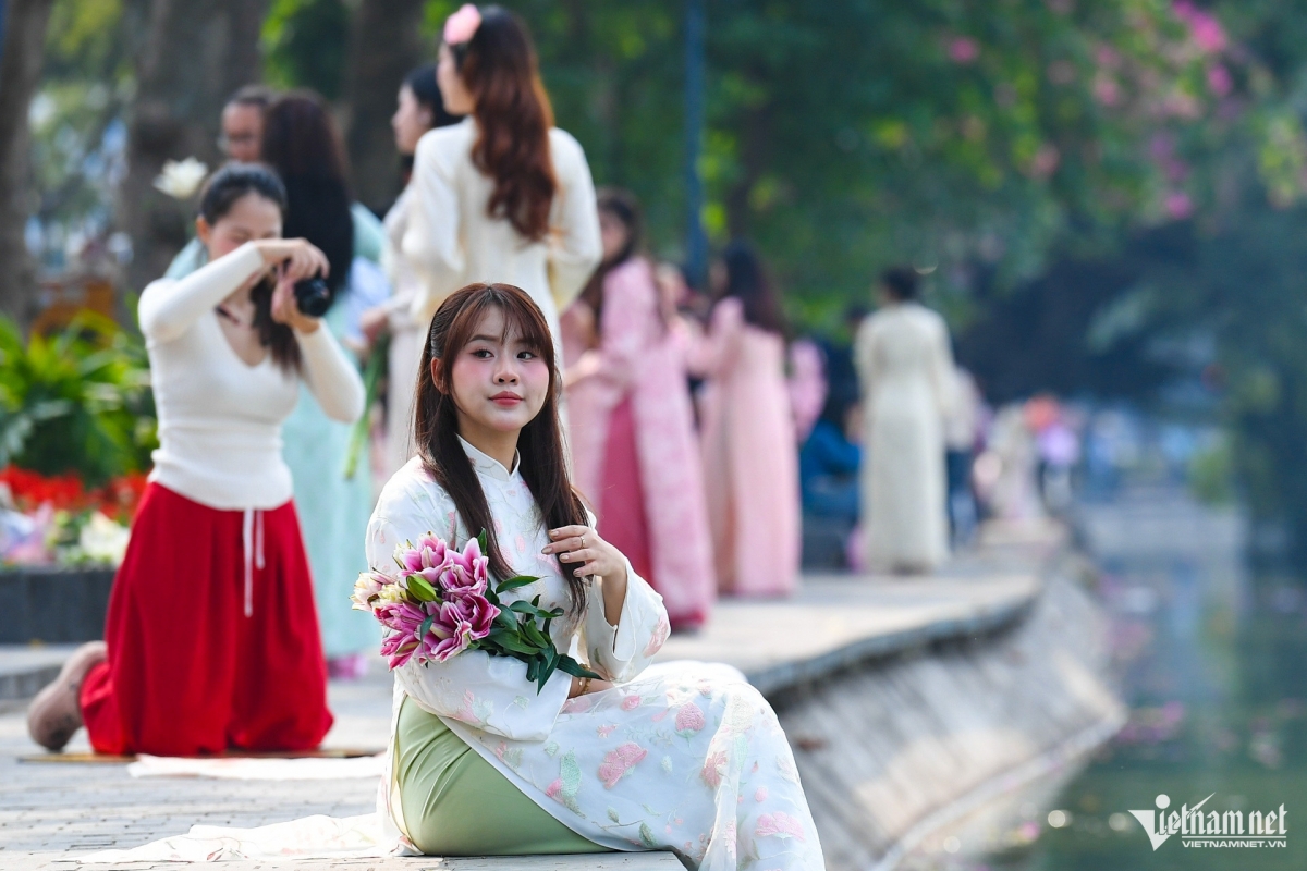 Những ngày giáp tết Nguyên đán, từ 9h, khu vực ven Hồ Gươm (Hà Nội) đã đông nghịt bạn trẻ đến chụp ảnh. Đa số diện trang phục áo dài, ngồi thả dáng, tạo kiểu để có những bức hình chơi Tết.