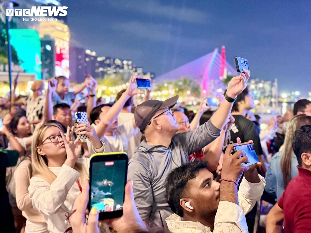 Many in the crowd seize the moment to capture the dazzling display on their mobile phones, preserving images of the fireworks as a keepsake of the first moments of a peaceful and hopeful new year in Ho Chi Minh City.
