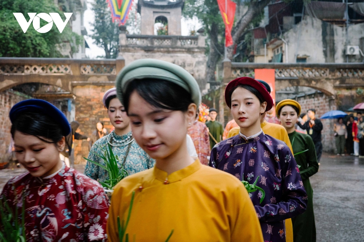 Young participants, dressed in traditional attire, parade through the Old Quarter with a dignified and graceful demeanor.