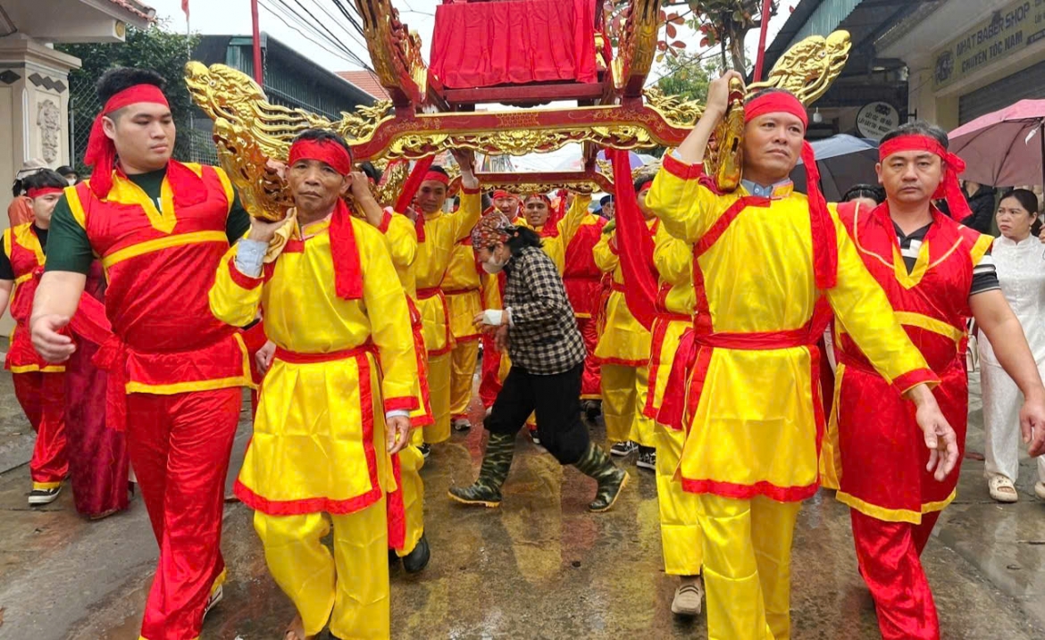 Người dân háo hức chui kiệu Thánh - một hình ảnh thường thấy trong các lễ hội đình làng truyền thống với với niềm tin và ước nguyện được ban phúc lành, sức khỏe dồi dào và bình an trong cuộc sống.