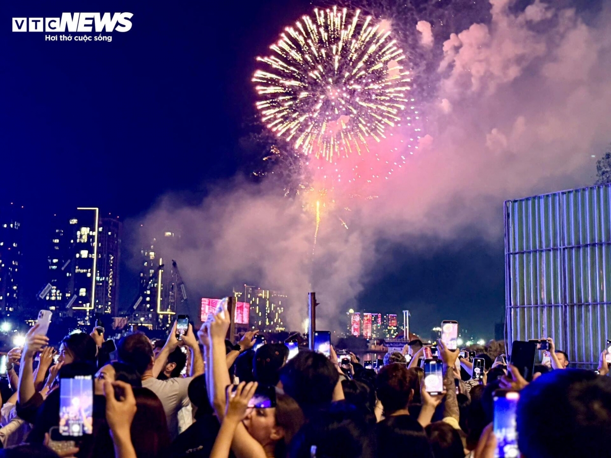 As the fireworks burst into the sky, the sea of spectators at Bach Dang Wharf lift their heads in unison, erupting in cheers that echoes along the riverside in a wave of excitement.