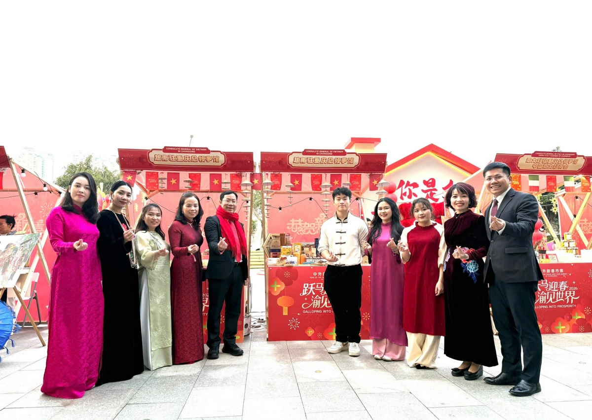 Cán bộ, công nhân viên Tổng lãnh sự quán Việt Nam Trùng Khánh chụp ảnh kỷ niệm tại gian hàng Việt