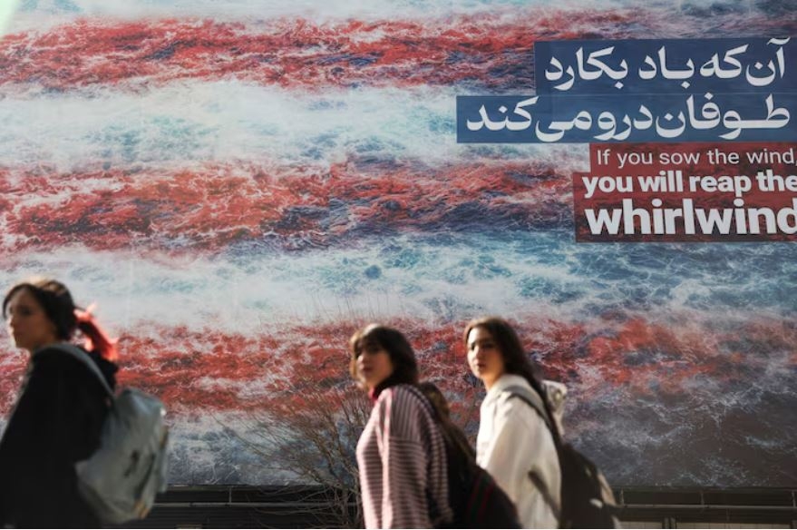 Người dân Iran đi qua một tấm áp phích có thống điệp phản đối Mỹ trên đường phố. Ảnh: Reuters