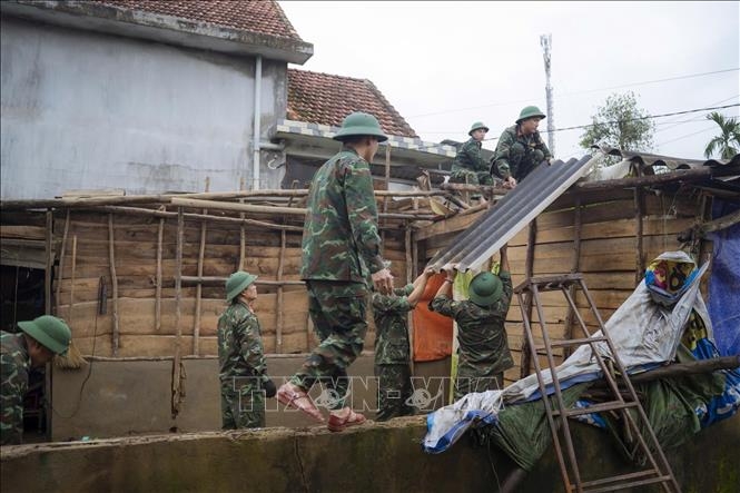 Lực lượng bộ đội ra quân giúp dân xây dựng và sửa chữa nhà cửa bị ảnh hưởng bởi mưa lũ tại xã Lộc An. Ảnh: Mai Trang/TTXVN