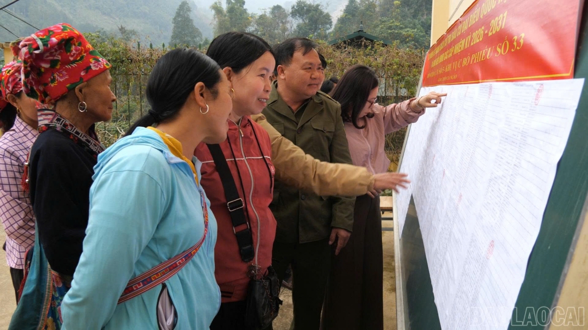 Người dân đang tìm tên mình trong danh sách cử tri (Ảnh Báo Lào Cai)