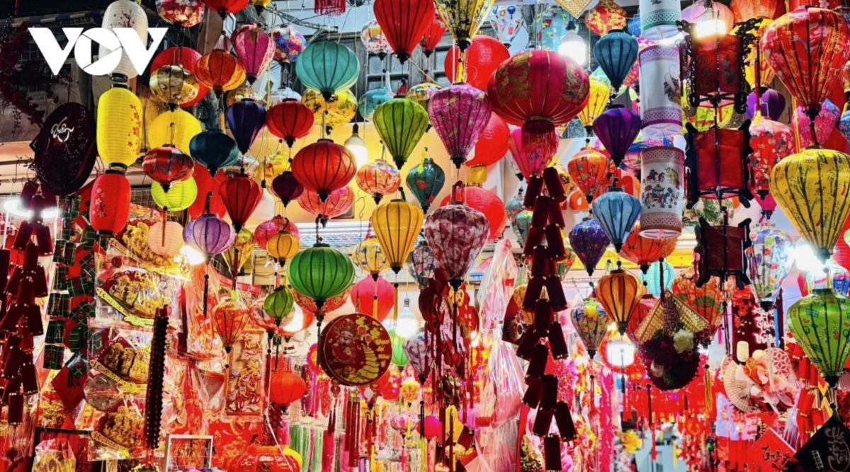 Red spring decorations cover the street, contrasting with the Old Quarter’s narrow traditional houses and creating a colourful festive scene.