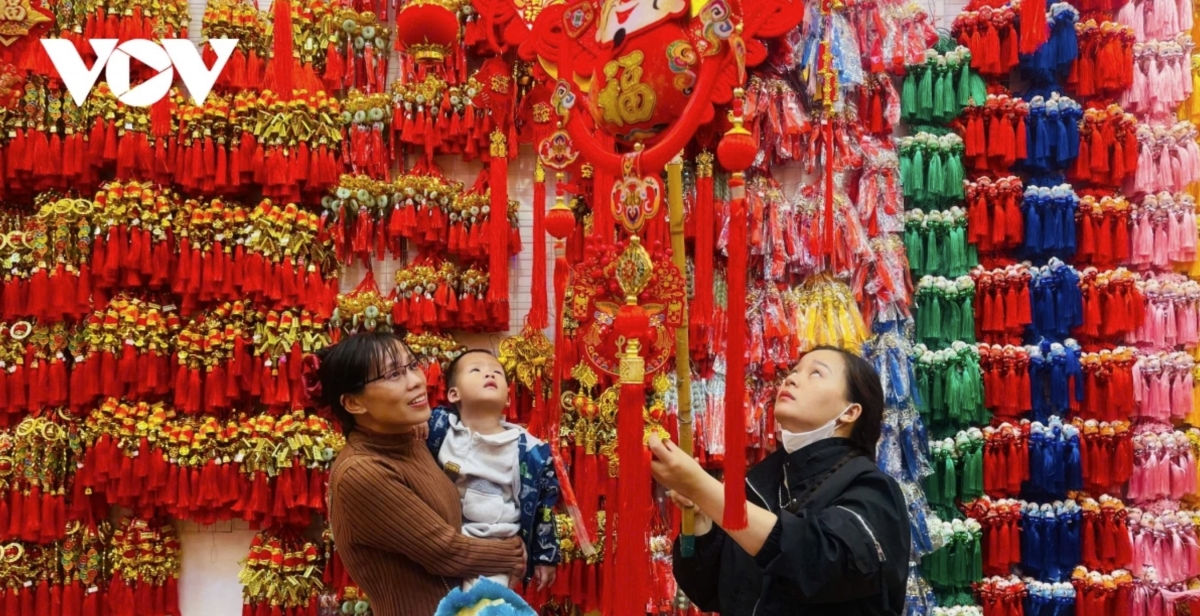 Families shop early for Lunar New Year decorations on Hang Ma street, choosing handmade traditional items to experience the Tet atmosphere.