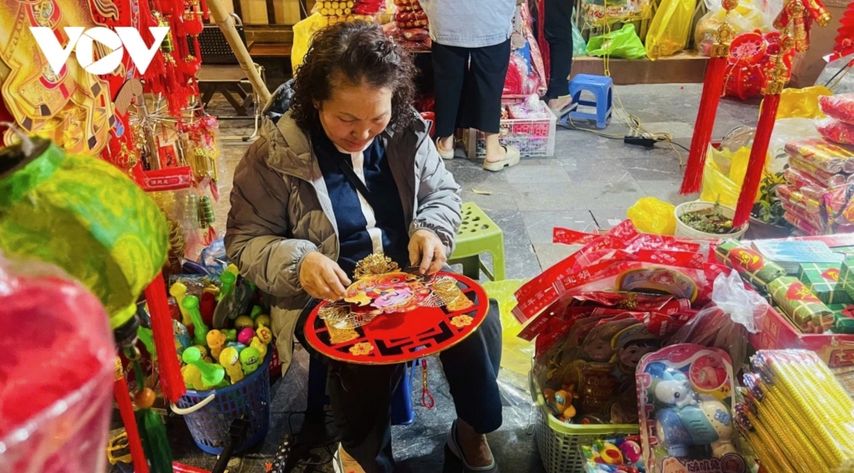 Shop owners on Hang Ma Street carefully prepare traditional Lunar New Year decorations, with prices this year remaining largely stable compared with last year, ranging from VND 50,000 to 800,000 per item.