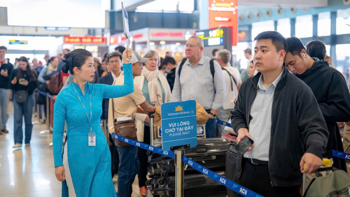 Nhân viên mặt đất của Vietnam Airlines hướng dẫn khách ở khu làm thủ tục vé.