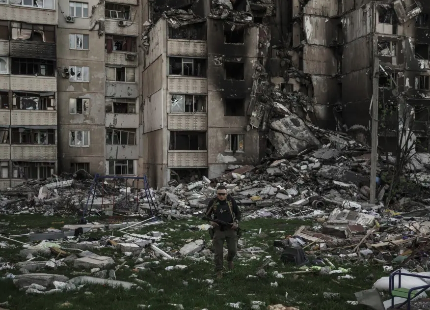 Binh sỹ Ukraine đi giữa đống đổ nát tại Kharkov. Ảnh: AP