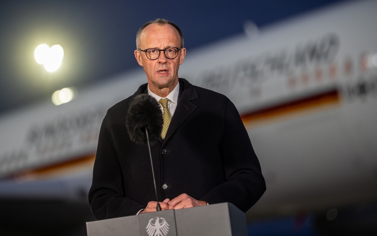 Thủ tướng Đức Merz phát biểu trước khi lên máy bay để bay sang Trung Quốc, ngày 24/2. Ảnh: DPA, AP.