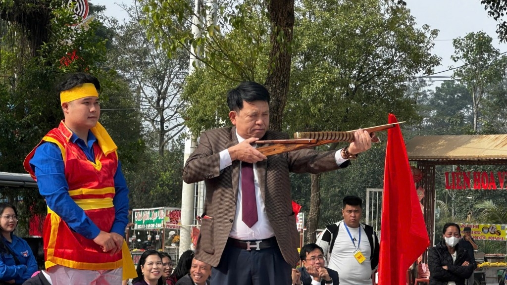 Phó bí thư Thường trực Đảng ủy xã Đông Anh Nguyễn Văn Cường thử sức bắn nỏ (Ảnh: Thái Sơn)