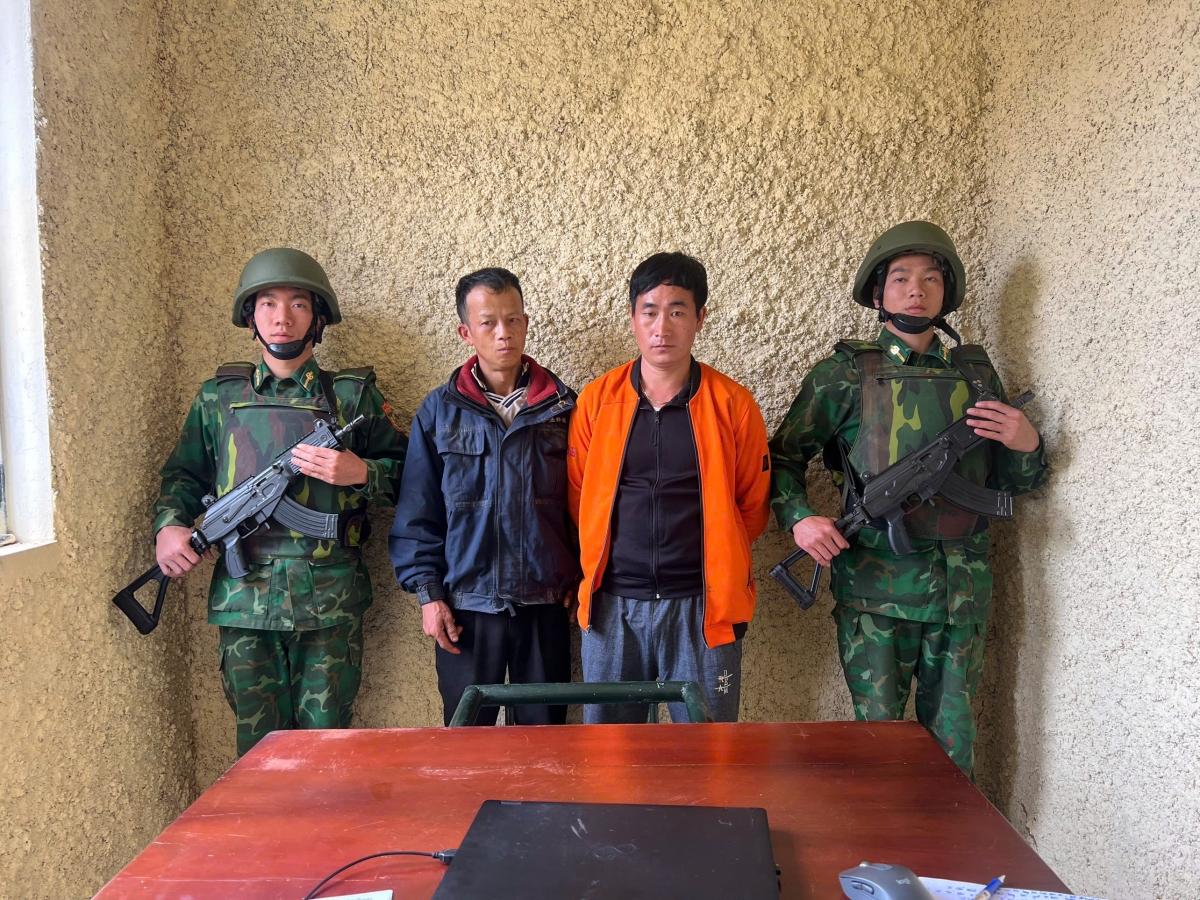 Hai đối tượng Lầu A Lềnh (mặc áo cam bên phải ảnh) và Sùng A Say tại cơ quan điều tra