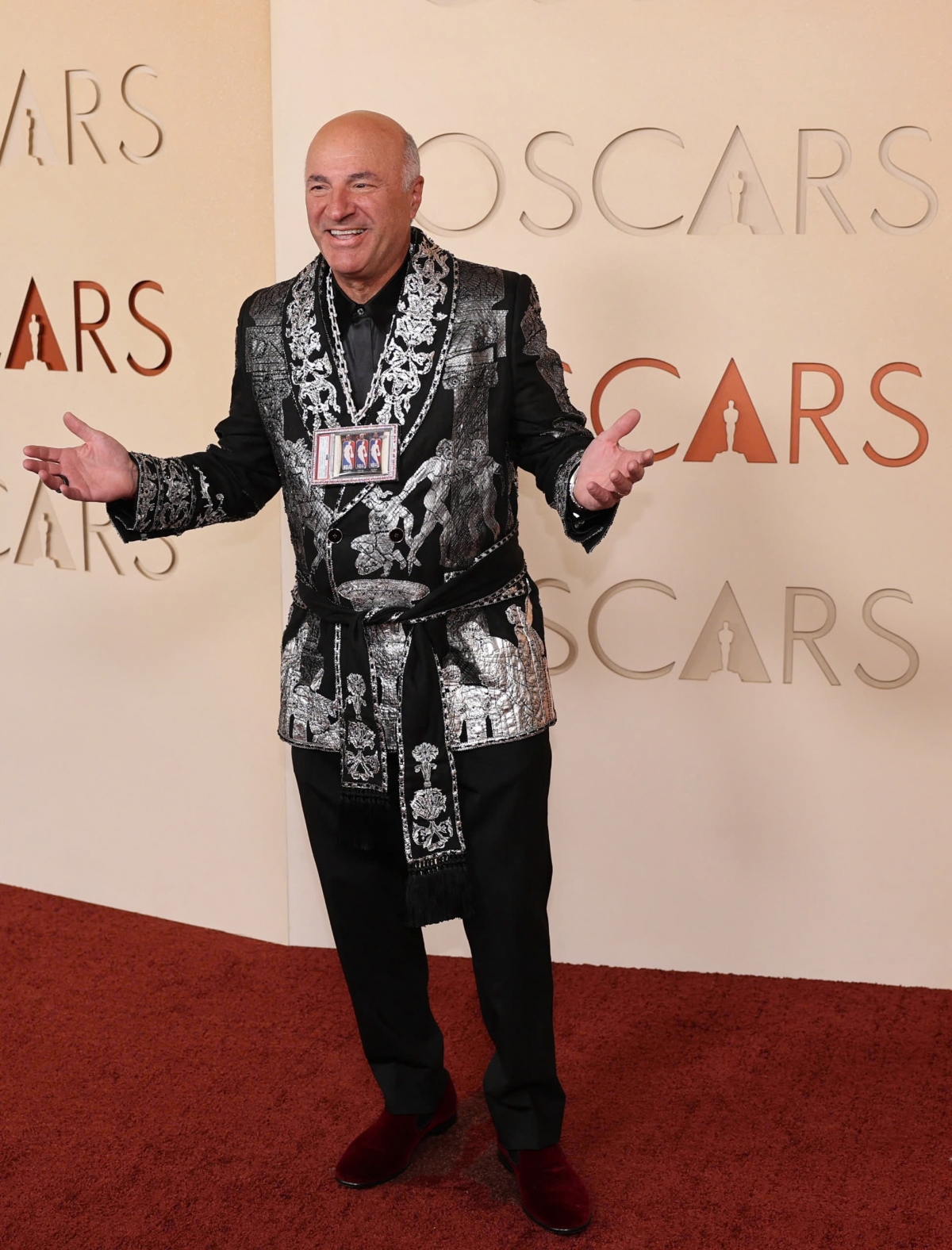 Doanh nhân truyền hình Kevin O'Leary lại gây chú ý bởi số lượng phụ kiện quá nhiều. Ông diện áo khoác Dolce &amp; Gabbana nổi bật, nhưng lại kết hợp cùng vòng cổ kim cương của Tiffany &amp; Co., hai chiếc đồng hồ và thẻ sưu tầm NBA, khiến tổng thể bị nhận xét là rườm rà.