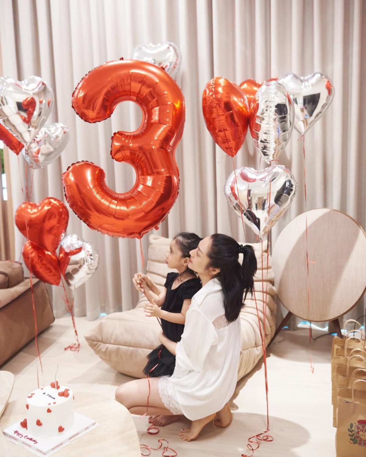 Buổi sinh nhật của bé Misumi được trang trí với bánh kem, bóng bay tông màu đỏ và trắng. 