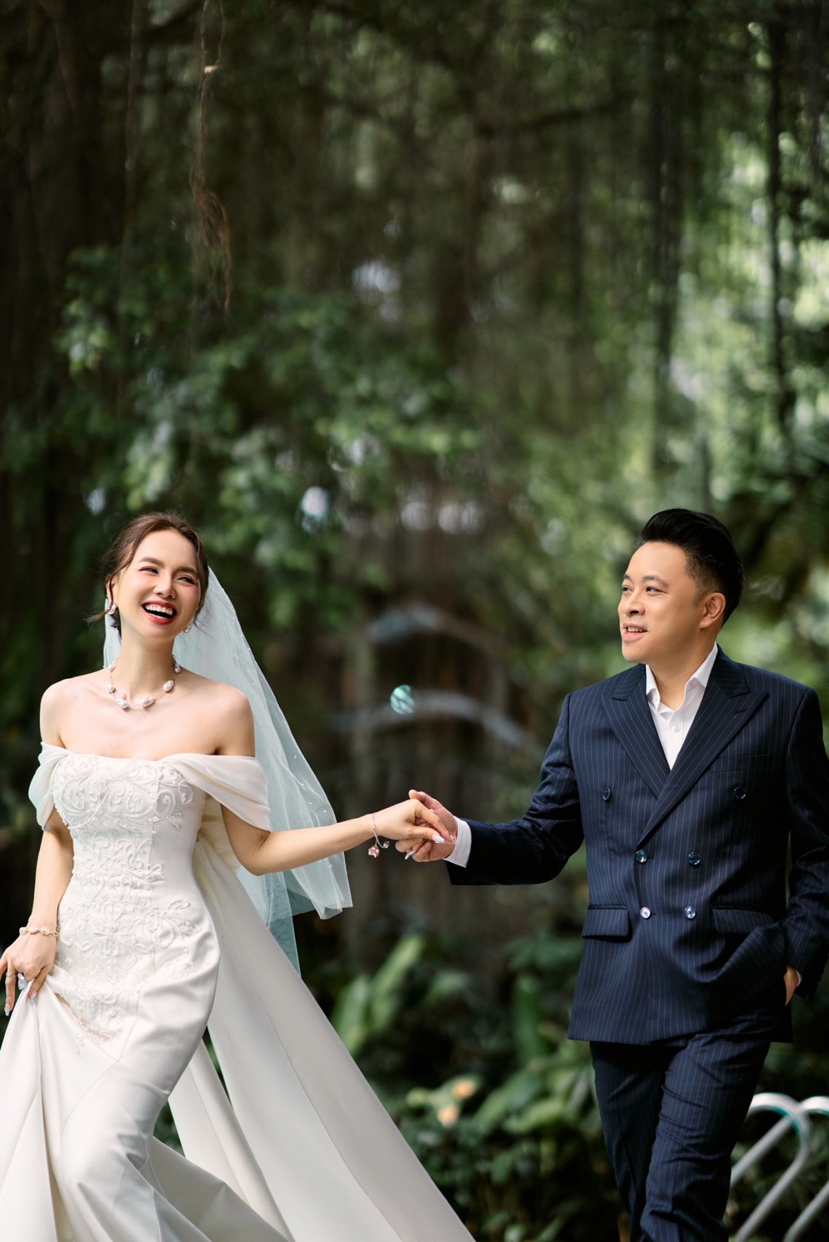 Trong bộ ảnh mới, Đinh Ngọc Diệp diện váy cưới trễ vai, ôm sát tôn dáng, kết hợp với voan dài phía sau. Đạo diễn Victor Vũ mặc vest kẻ sọc cùng áo sơ mi trắng. 