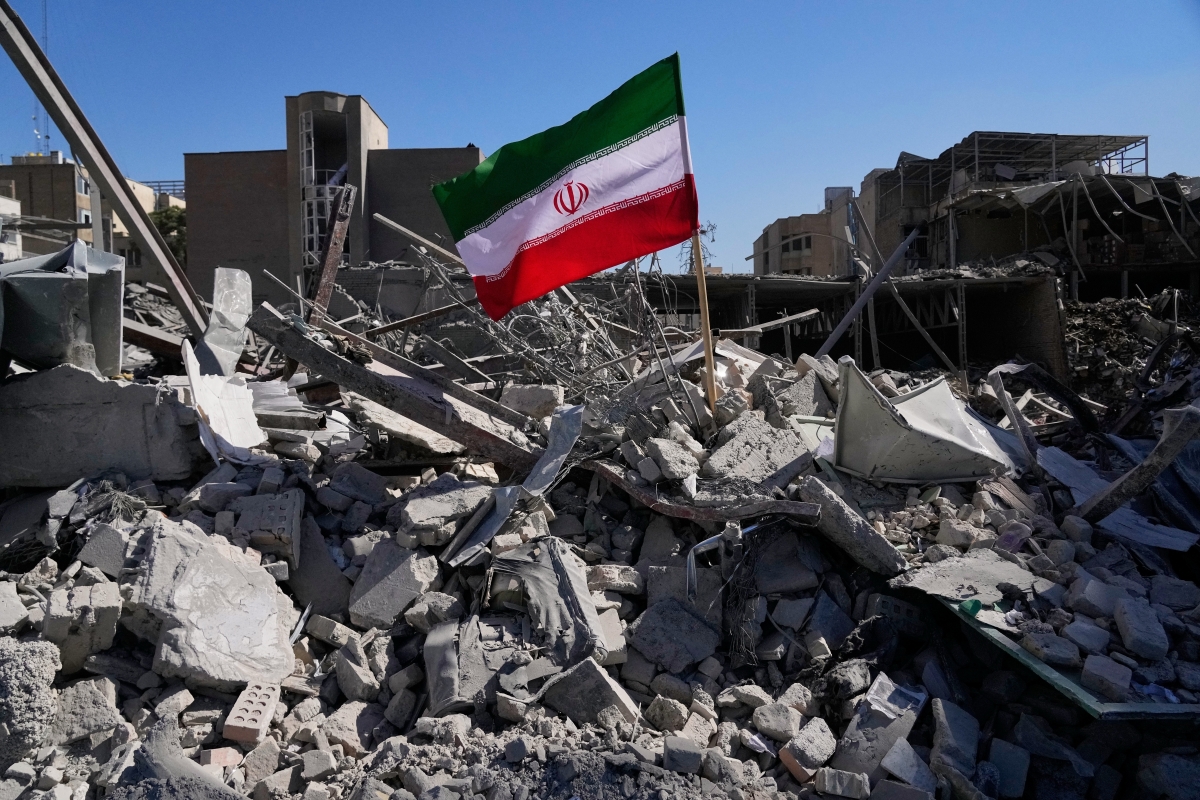 Một lá cờ của Iran được cắm giữa đống đổ nát sau cuộc không kích của Mỹ và Israel ngày 3/3/2026. Ảnh: AP