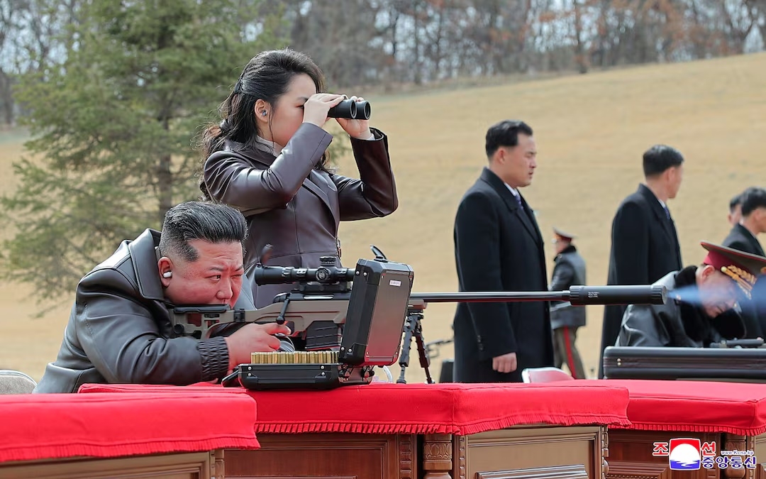 Lãnh đạo Kim Jong Un ngắm bắn súng bắn tỉa mới của Triều Tiên. Con gái ông, Kim Ju Ae, đứng bên cạnh và nhìn xa bằng ống nhòm. Ảnh: KCNA.