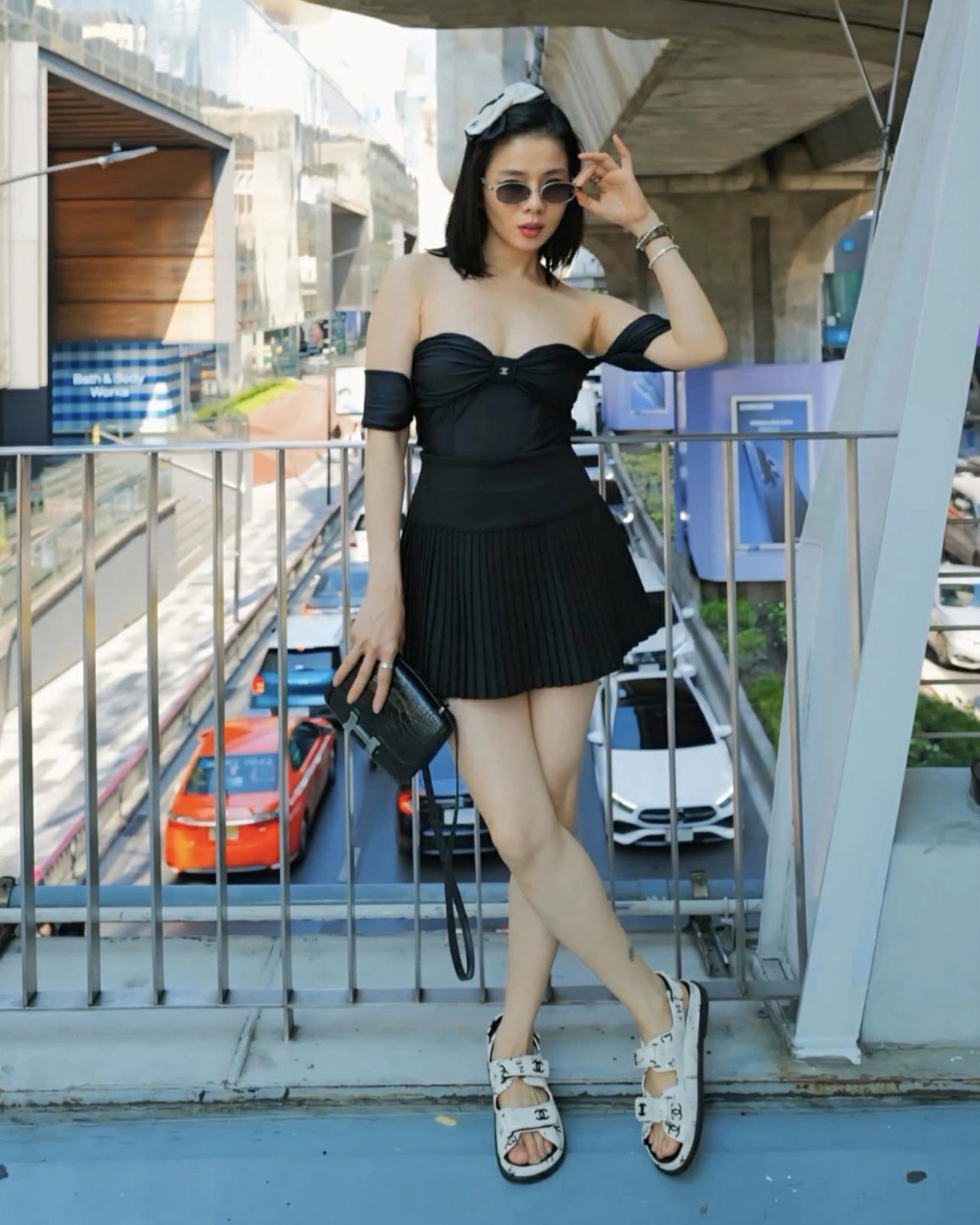 Lệ Quyên mặc áo trễ nải phối chân váy xếp ly tươi trẻ dạo phố Thái Lan.