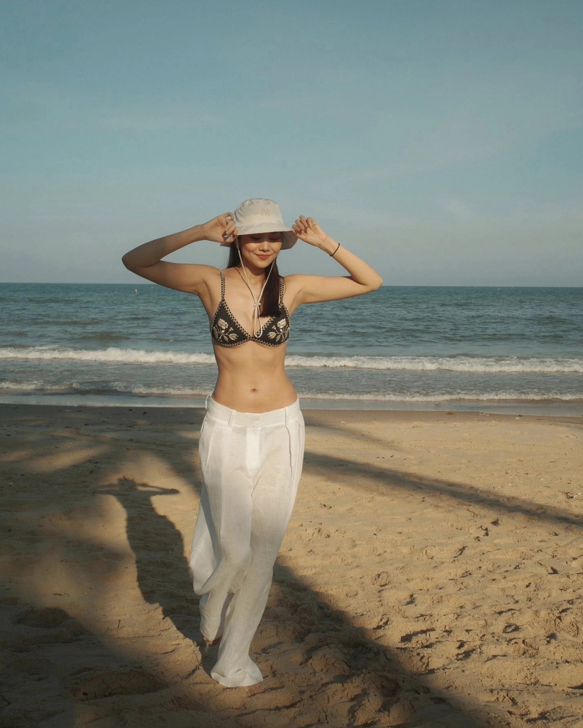 Thanh Hằng khoe vẻ gợi cảm với bikini phối cùng quần dài trên biển.