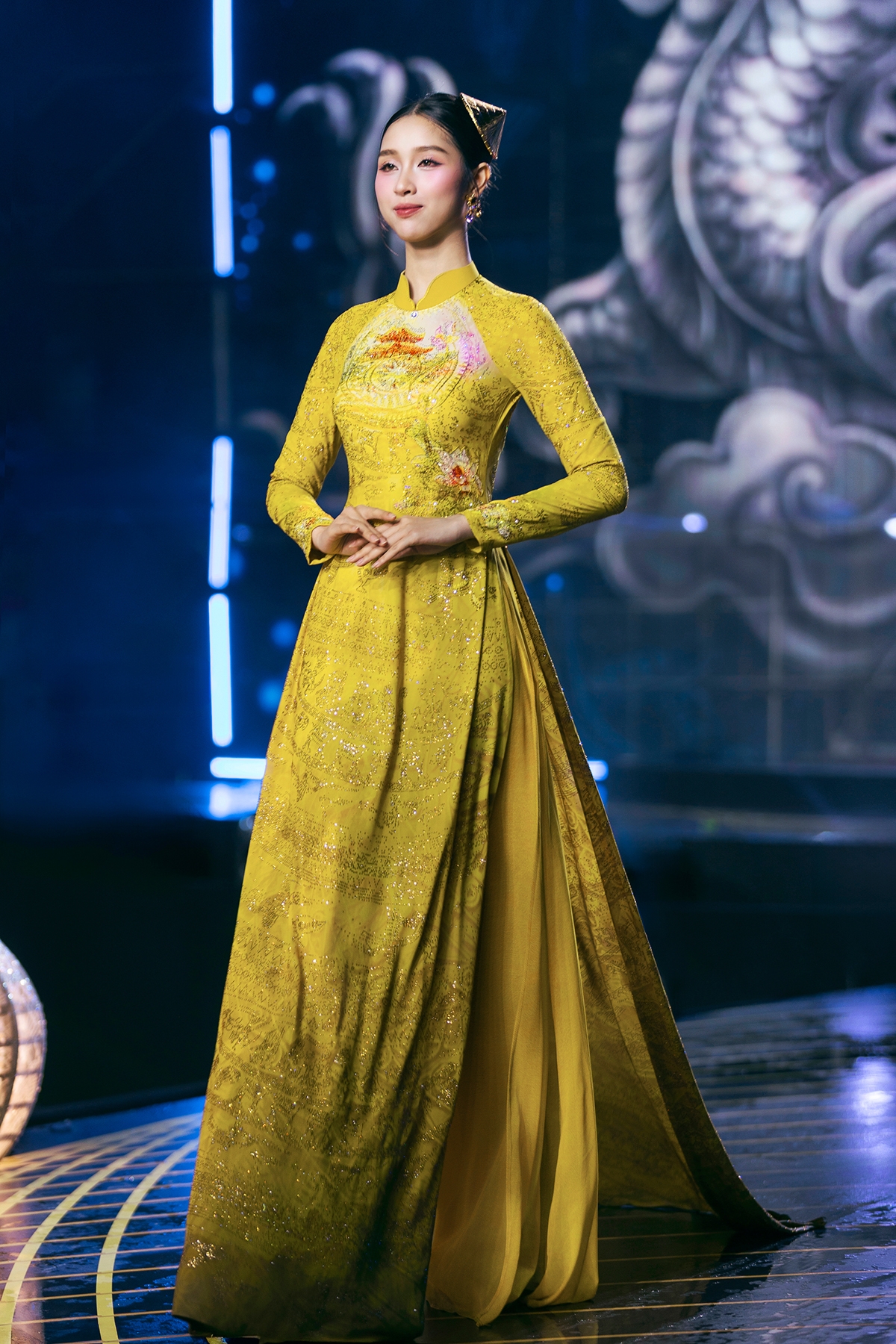 Từng chi tiết trên nền lụa SVF được sắp đặt công phu, kết hợp đá, pha lê và thêu tay thủ công từ hàng trăm nghệ nhân góp phần tạo nên một “bức tranh đá quý” trên tà áo dài.