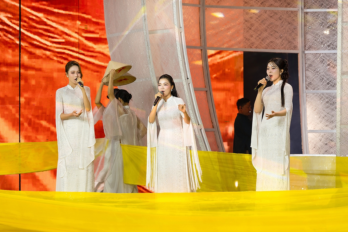 Ca sĩ, Á hậu Ngọc Hằng; Hoa hậu Kiều Duy và ca sĩ Thanh Ngọc trong thiết kế áo dài trắng thêu đính đá quý với họa tiết thổ cẩm, tái hiện vẻ đẹp tinh hoa văn hóa dân tộc và lan tỏa giá trị áo dài Việt trên sân khấu nghệ thuật.