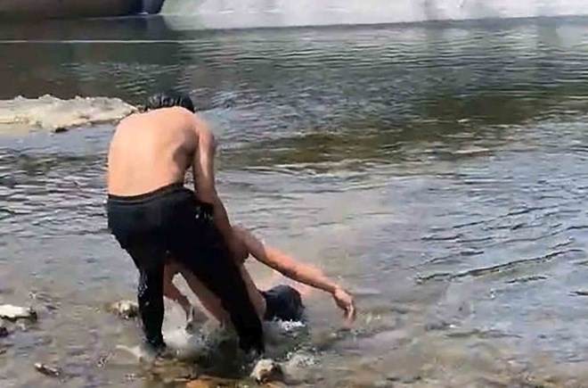 Anh Lê Khắc Hà đang nỗ lực đưa nam sinh bị đuối nước lên bờ.