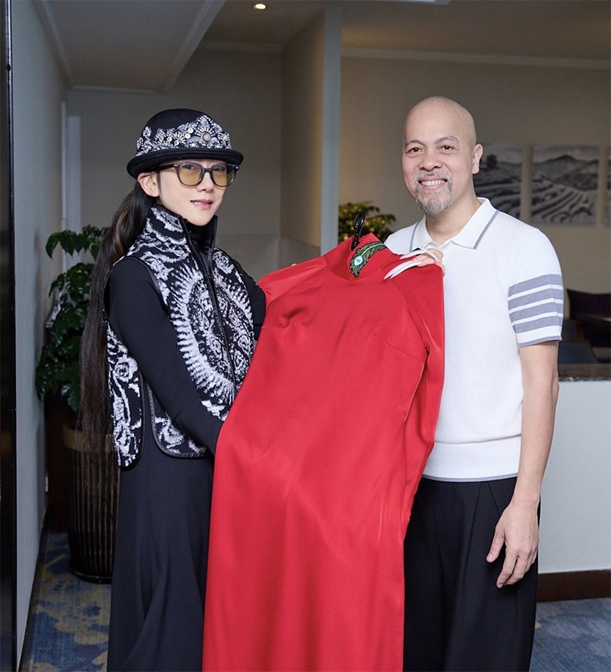 Nhà thiết kế Đức Hùng ra mắt thiết kế áo dài đặc biệt dành riêng cho khổng tước Dương Lệ Bình, nổi bật với lụa đỏ thắm, điểm xuyết lông khổng tước nơi cổ áo. Thiết kế lấy cảm hứng từ vũ điệu chim khổng tước trứ danh của bà.