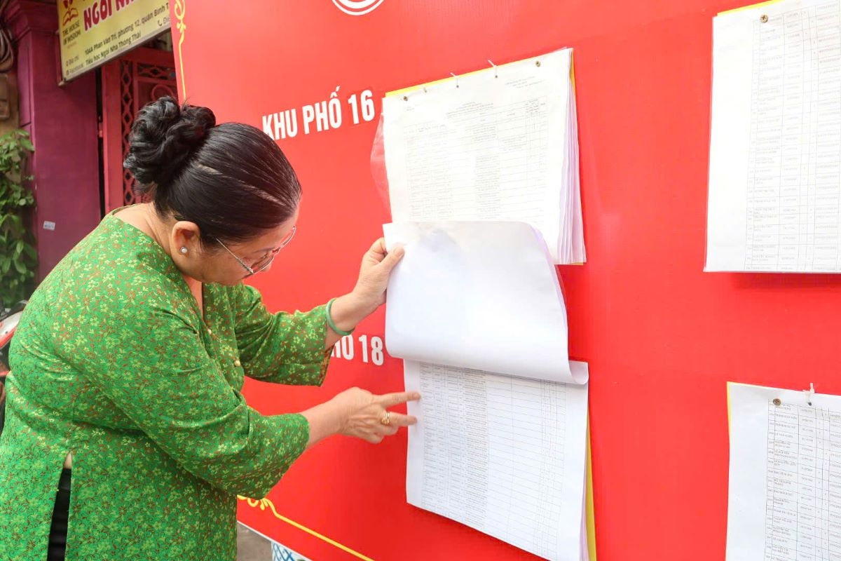 Bà Phan Thị Huỳnh Trinh kiểm tra thông tin trong danh sách cử tri tại điểm niêm yết của tổ bầu cử