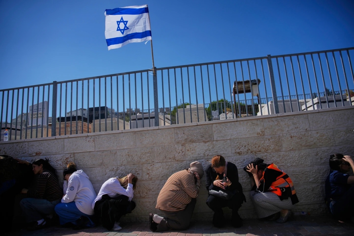 Người dân Israel tìm chỗ trú ẩn khi còi báo động vang lên, cảnh báo các tên lửa từ Iran đang bay tới Israel. (Ảnh: AP)