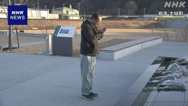 Một người thân của nạn nhân đã đến đài tưởng niệm đặt hoa, chắp tay cầu nguyện và tưởng nhớ đến những người đã thiệt mạng vì thảm họa kép thiên nhiên - Ảnh: NHK