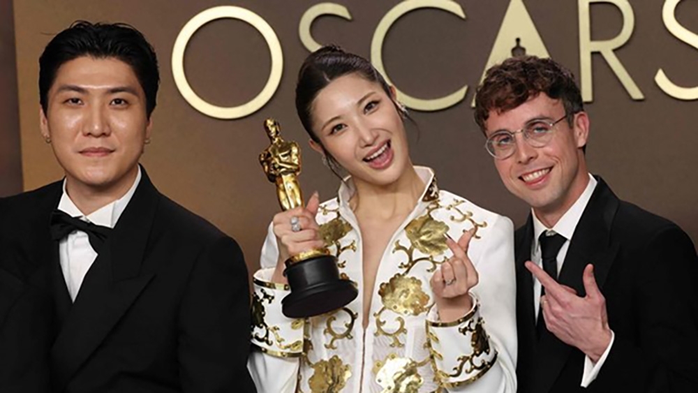 Từ trái sang, Seo Jeong Hoon, Ejae và Mark Sonnenblick tạo dáng cùng tượng vàng Oscar cho Ca khúc gốc hay nhất với bài hát “Golden” từ phim “KPop Demon Hunters” tại Lễ trao giải Oscar lần thứ 98. (Ảnh: Yonhap)