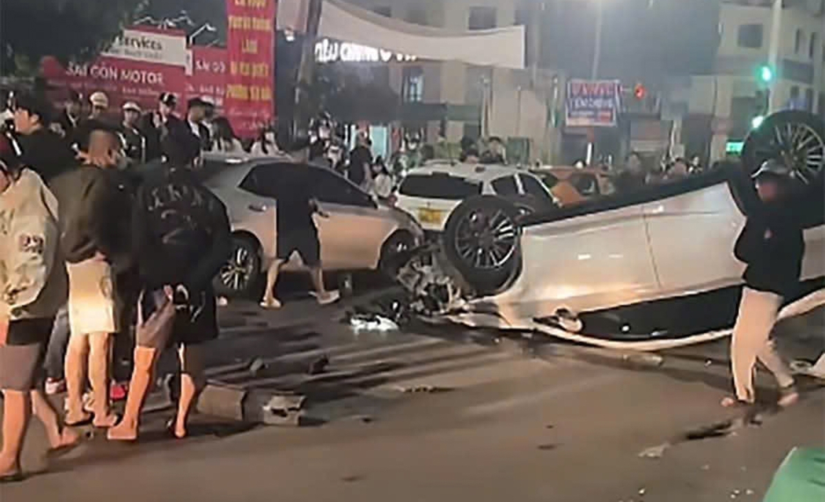 Cú tông mạnh khiến ô tô Lexus RX350 lật ngửa, phần đầu và đuôi xe biến dạng, mảnh vỡ văng tung tóe khắp mặt đường. 