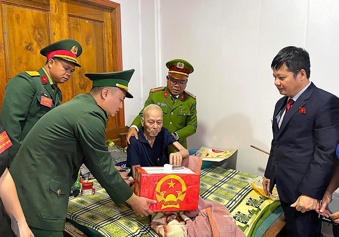 Ông Nguyễn Anh Đoài, Bí thư Đảng ủy xã Mỹ Lý cùng lực lượng chức năng đưa hòm phiếu phụ đến nhà để cử tri già yếu bỏ phiếu. (Ảnh: BT).